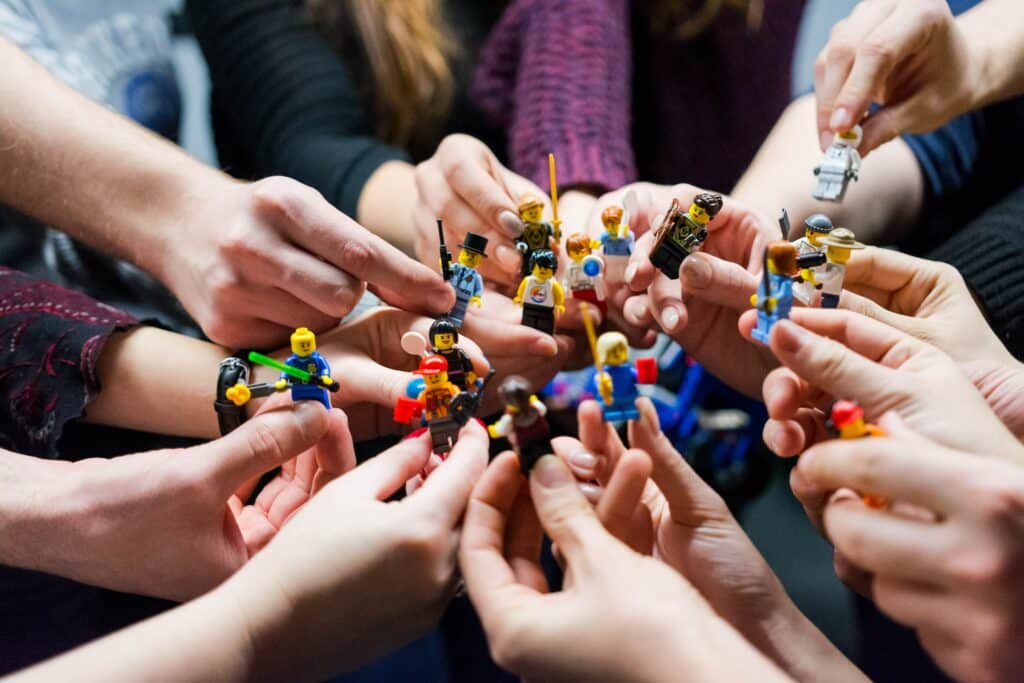 jeux d'entreprise team building, personnes tenant des personnages lego